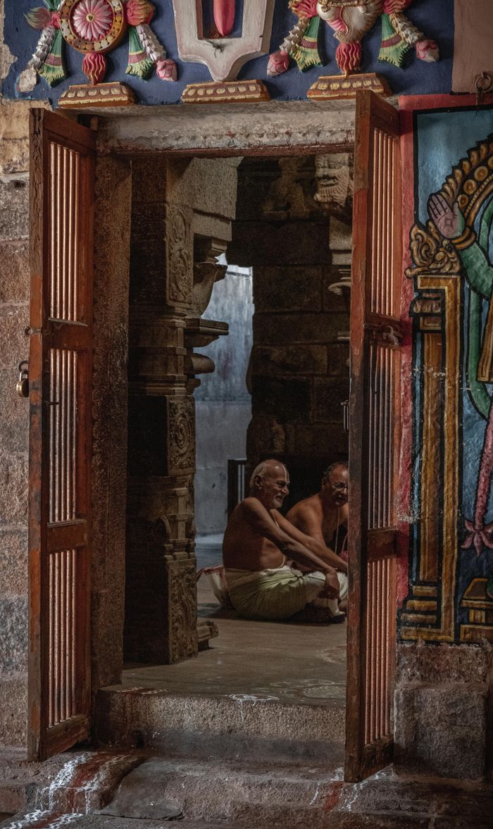 Priests seated inside a traditional Hindu temple